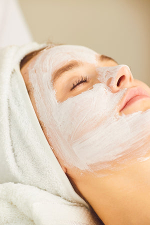 Woman enjoying a relaxing BlushByEve facial treatment.
