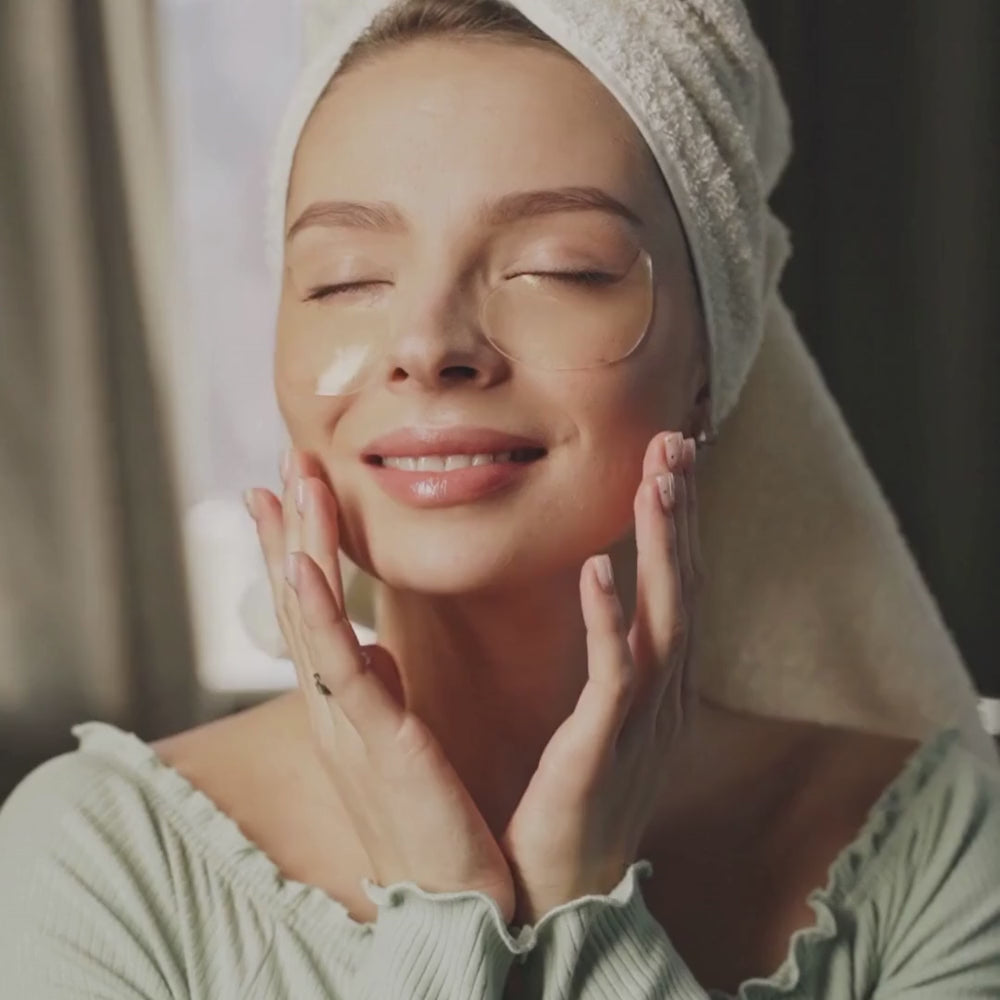 Young woman with eye patches, gently applying BlushByEve skincare products, showcasing radiant self-care.